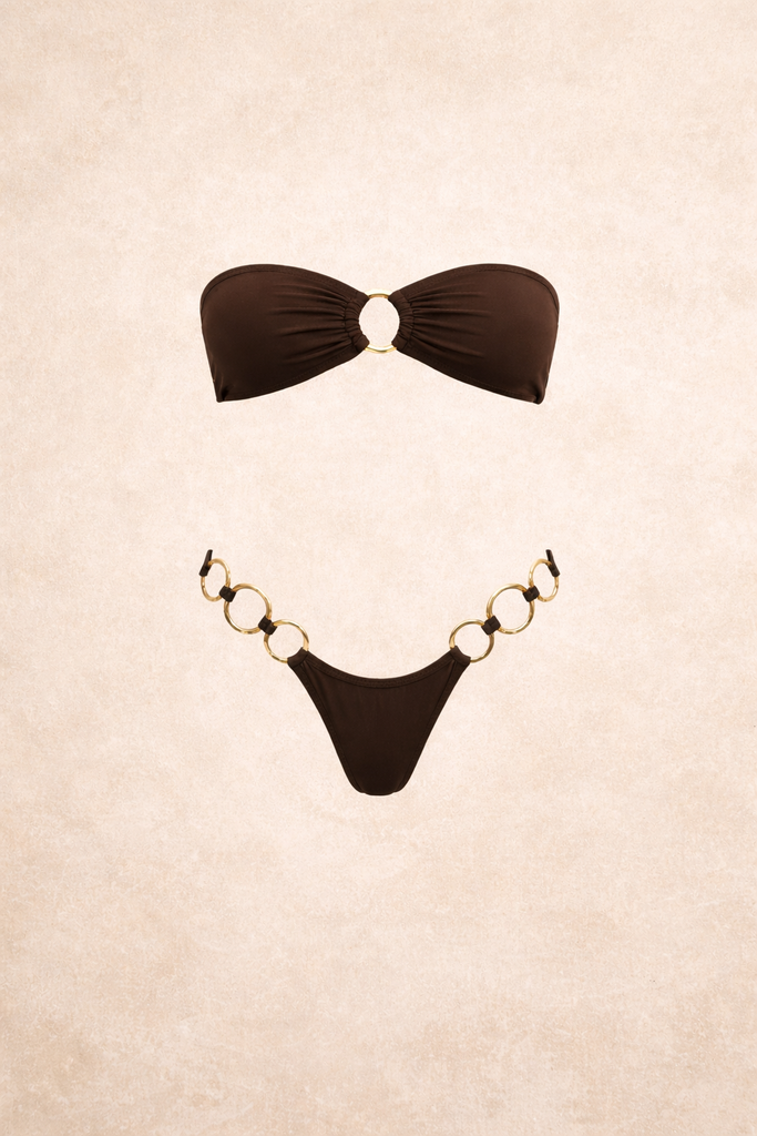 Black bandeau bikini set with gold ring hardware and high-cut bottoms. Minimal, sexy swimwear designed for a sleek elevated beach look.