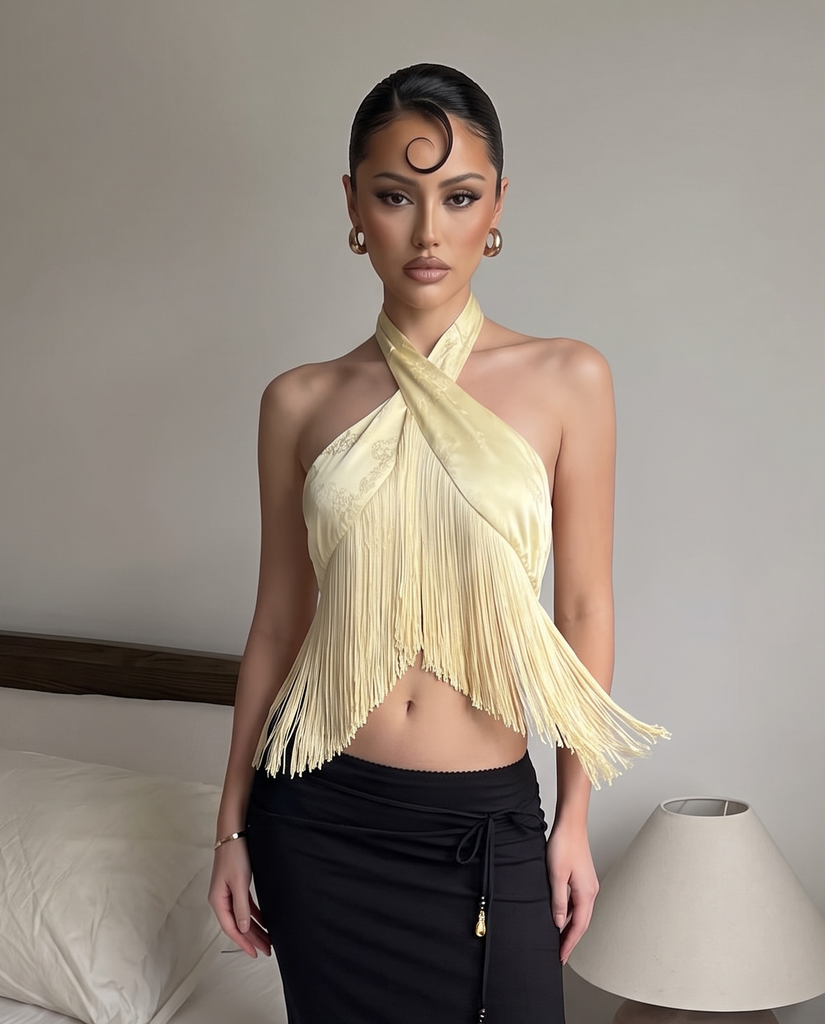 Butter yellow fringe halter top featuring a crisscross neckline and asymmetrical hem.